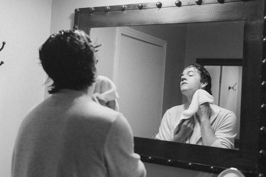 Black and white photograph of a groom getting ready at The Gage Hotel in Marathon, Texas. 