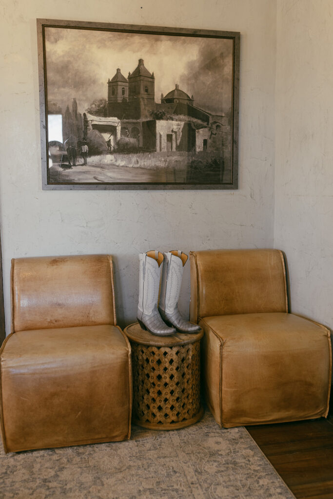 Lucchese cowboy boots displayed between to chairs in the Captain Shepherd House at the Gage Hotel in Marathon, Texas.